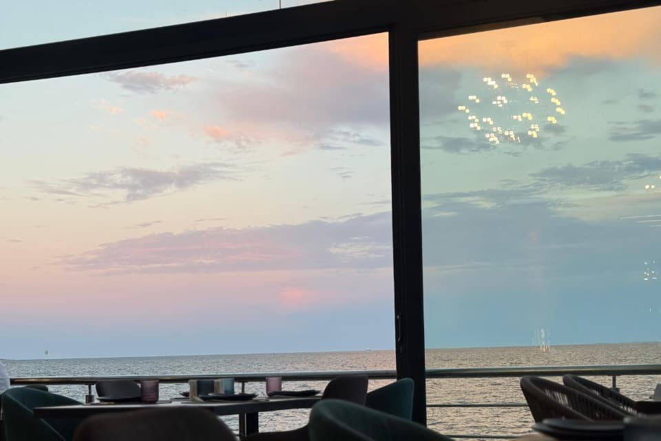 Table set for dining with a sunset view over the sea from SALT's window